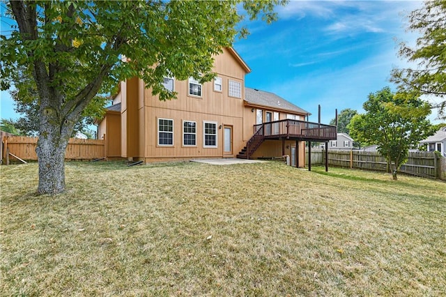 rear view of house featuring a yard and a deck