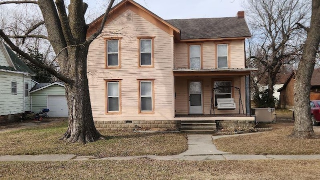 view of front facade with a porch, a garage, an outdoor structure, and a front lawn