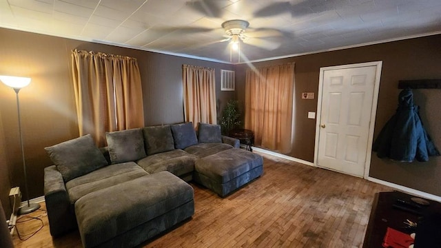 living room with crown molding, ceiling fan, and wood-type flooring