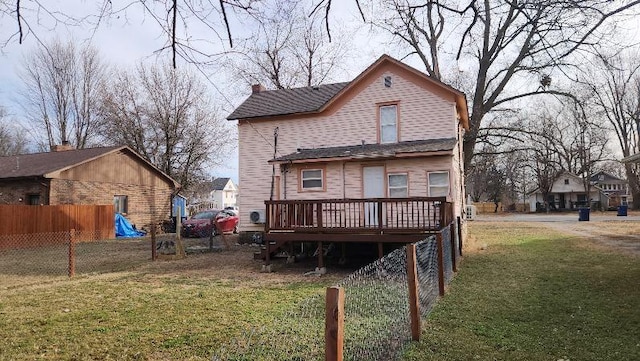 rear view of property with a wooden deck and a yard