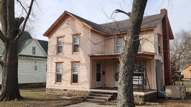 view of front facade featuring crawl space, covered porch, and a chimney