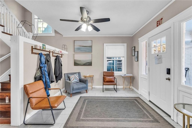 tiled entryway with crown molding and ceiling fan