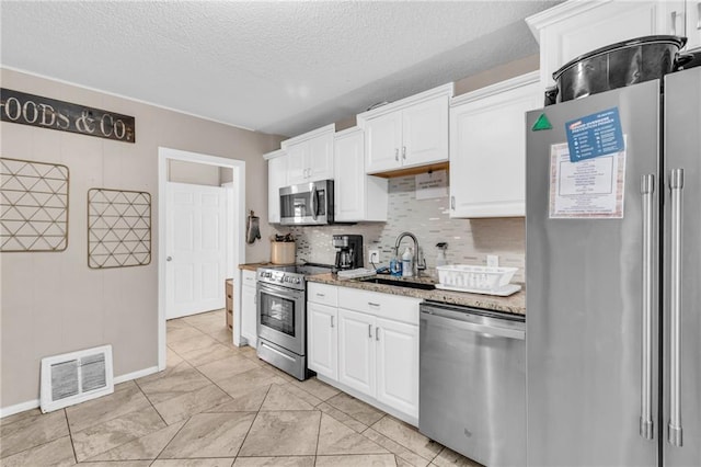 kitchen featuring white cabinetry, appliances with stainless steel finishes, sink, and a textured ceiling