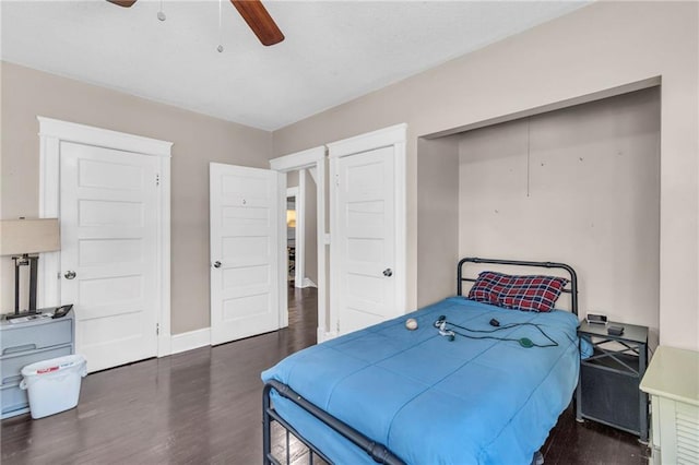 bedroom with a closet, dark hardwood / wood-style floors, and ceiling fan