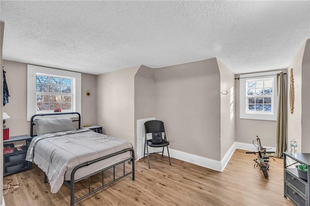 bedroom featuring light hardwood / wood-style floors and a textured ceiling