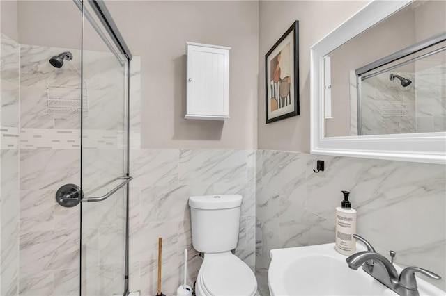 bathroom with tile walls, sink, toilet, and tiled shower