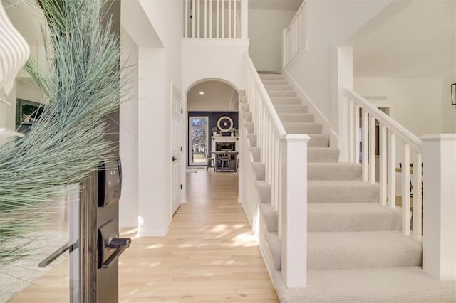 foyer entrance with a towering ceiling and light hardwood / wood-style floors