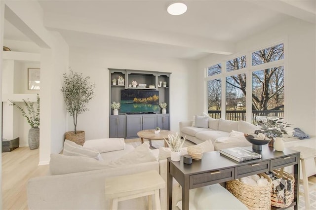 living room with light hardwood / wood-style floors and beamed ceiling