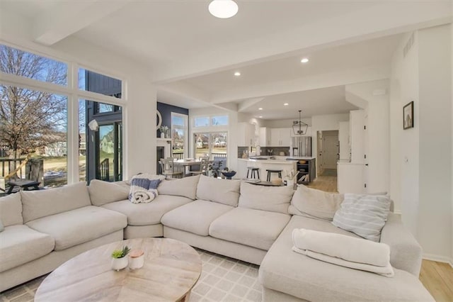 living room with beamed ceiling and light wood-type flooring