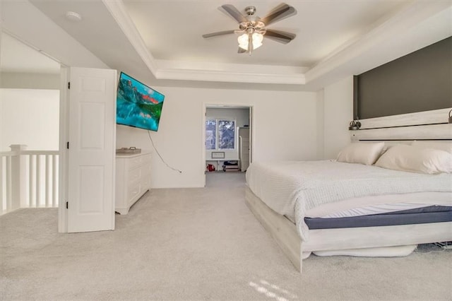 carpeted bedroom featuring a tray ceiling and ceiling fan