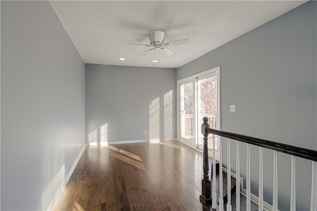 empty room with hardwood / wood-style floors and ceiling fan