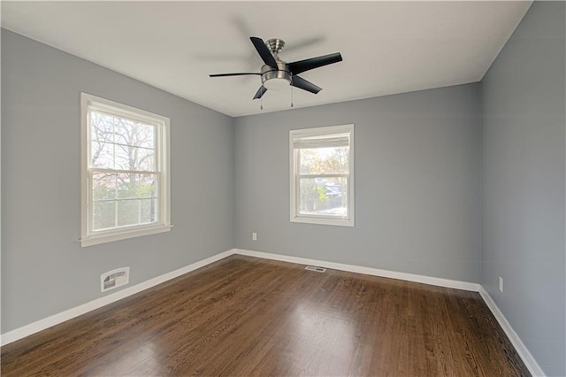 empty room with ceiling fan, dark wood-type flooring, and a healthy amount of sunlight