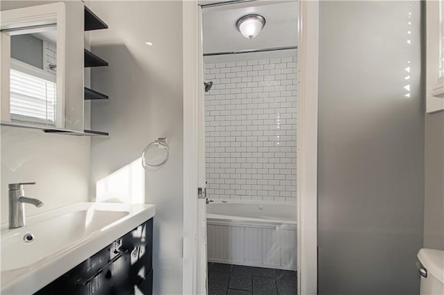 full bathroom featuring tile patterned flooring, sink, tiled shower / bath combo, and toilet