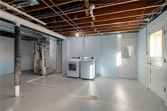 basement featuring washing machine and clothes dryer and heating unit