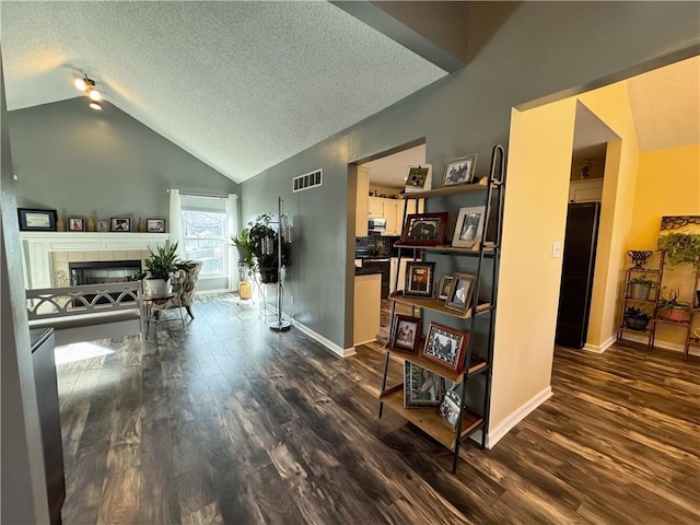 interior space with dark hardwood / wood-style flooring, lofted ceiling, and a textured ceiling