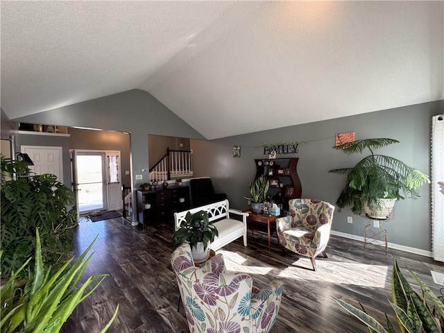 living room with lofted ceiling, dark hardwood / wood-style floors, and a textured ceiling