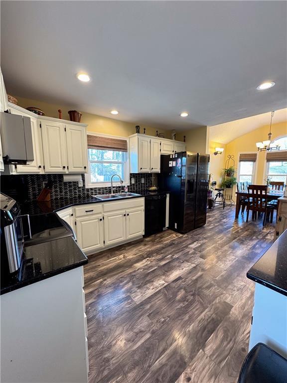 kitchen featuring a healthy amount of sunlight, sink, white cabinets, and black appliances