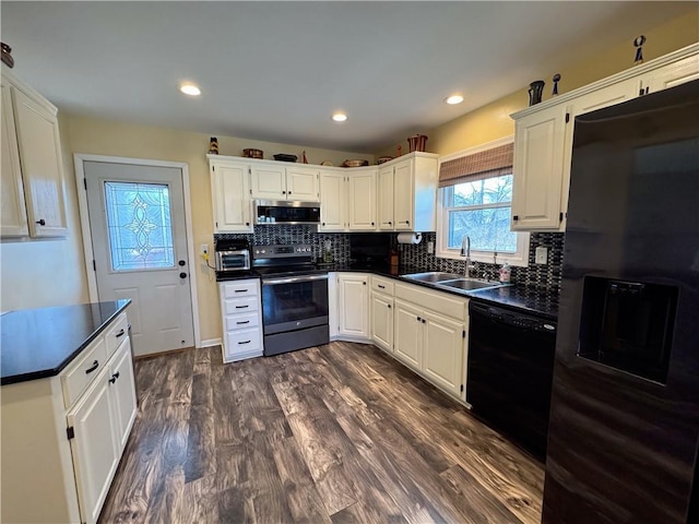 kitchen featuring sink, black appliances, white cabinets, dark hardwood / wood-style flooring, and decorative backsplash