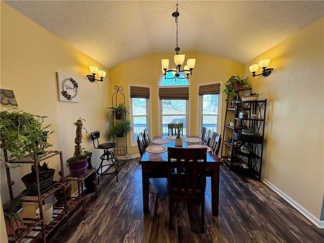 dining room featuring dark wood-type flooring, vaulted ceiling, and a textured ceiling