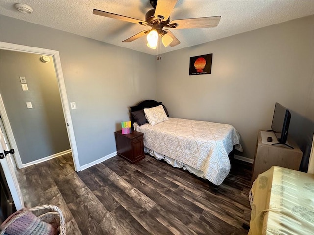 bedroom with ceiling fan, a textured ceiling, and dark hardwood / wood-style flooring