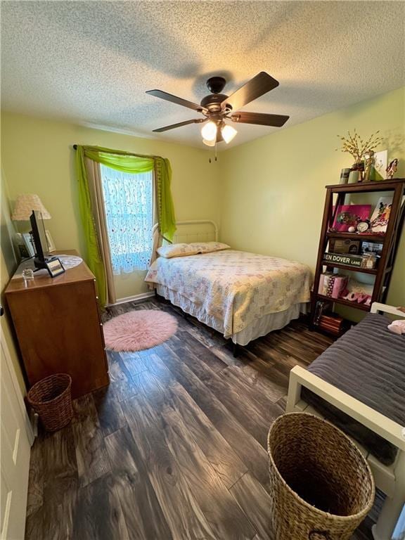 bedroom featuring ceiling fan, a textured ceiling, and dark hardwood / wood-style flooring