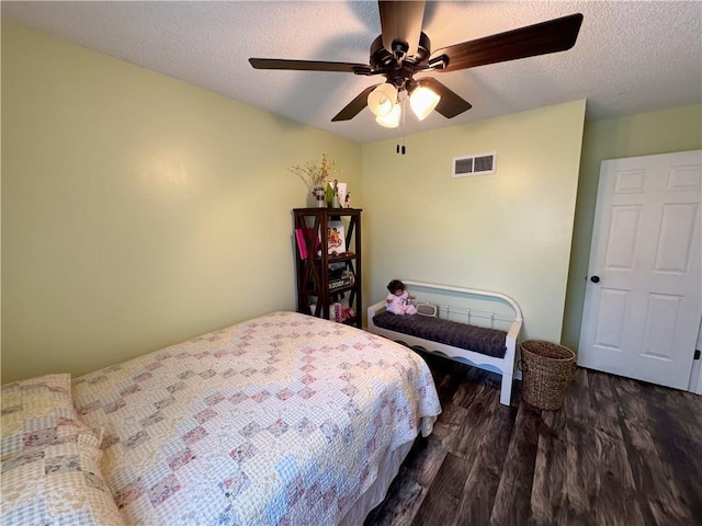 bedroom featuring ceiling fan, dark hardwood / wood-style floors, and a textured ceiling