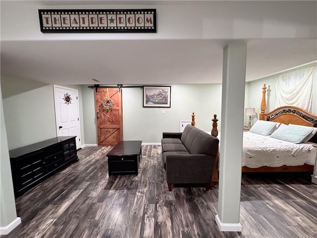 bedroom featuring a barn door and dark hardwood / wood-style flooring