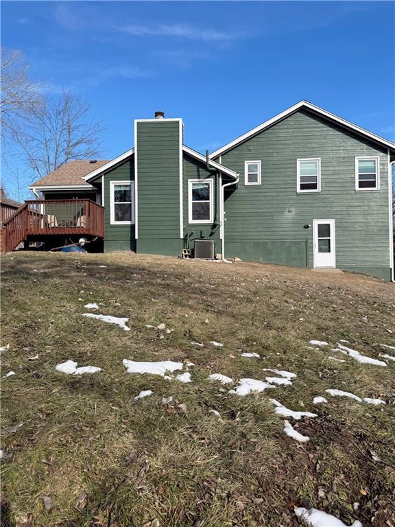 rear view of property with central AC unit and a deck