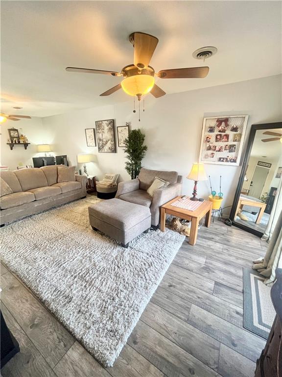 living room with ceiling fan and wood-type flooring