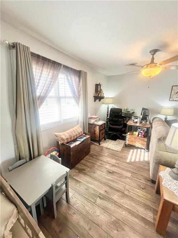 living room with ceiling fan and light wood-type flooring