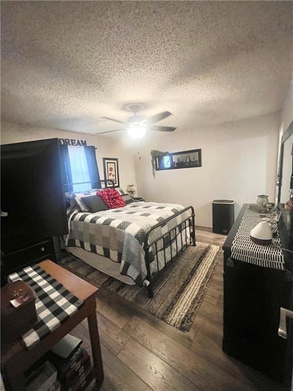 bedroom featuring a textured ceiling, dark hardwood / wood-style floors, and ceiling fan