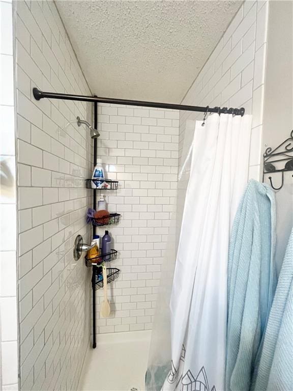 bathroom with a shower with shower curtain and a textured ceiling