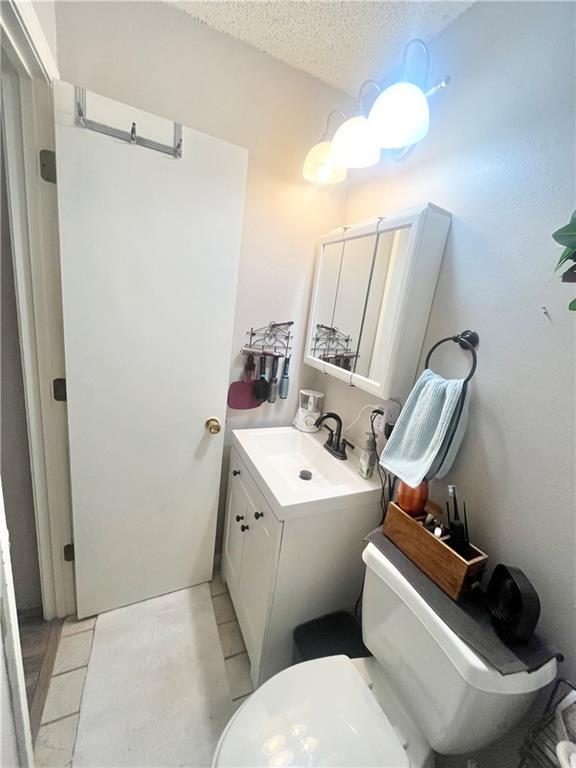 bathroom with vanity, tile patterned floors, a textured ceiling, and toilet