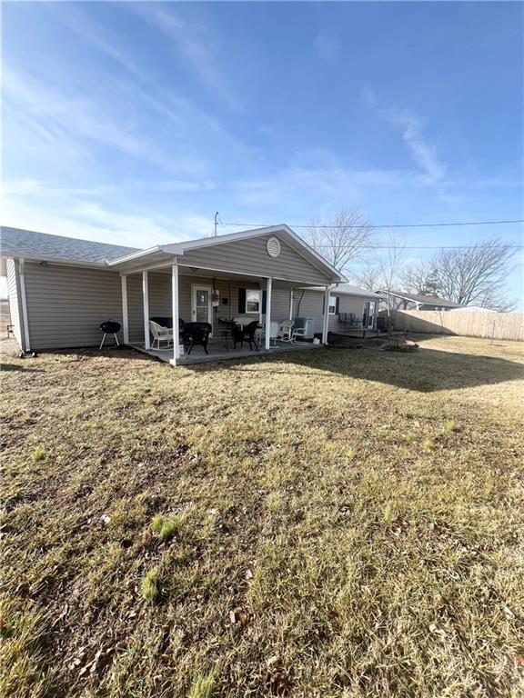 rear view of house featuring a lawn and a patio area