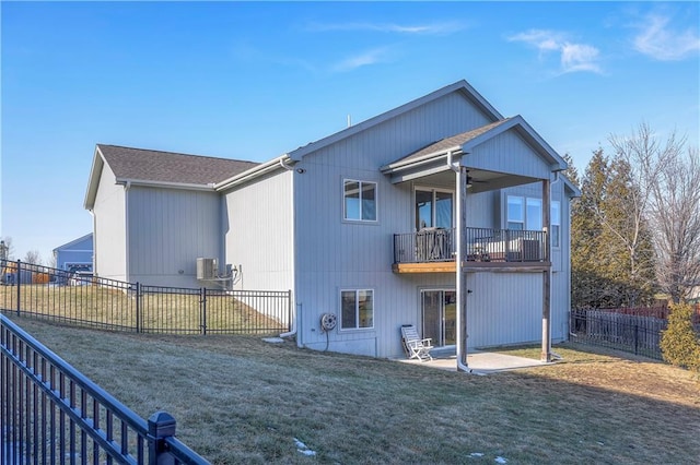 rear view of house with a balcony, a patio, a fenced backyard, a ceiling fan, and a yard