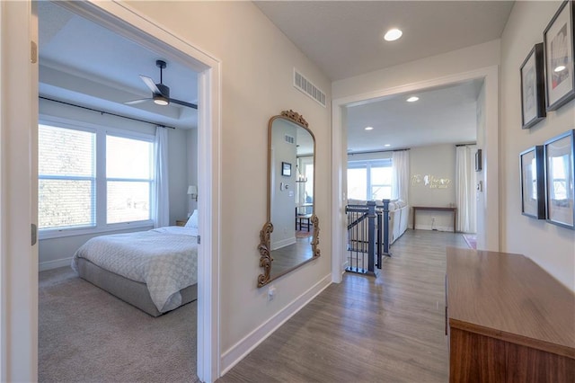 hall with baseboards, visible vents, wood finished floors, and recessed lighting