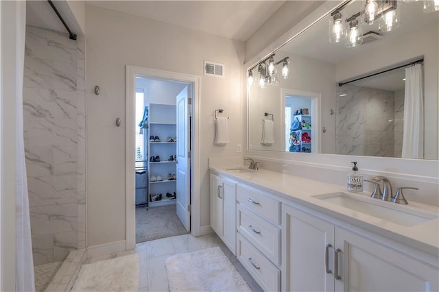 full bathroom with visible vents, marble finish floor, a marble finish shower, a sink, and a spacious closet