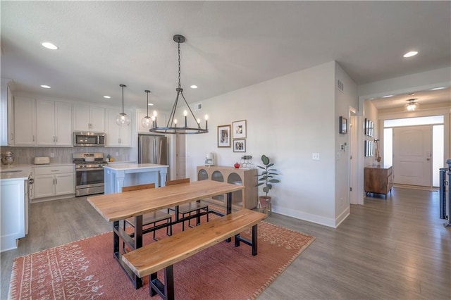 dining area featuring visible vents, a chandelier, baseboards, wood finished floors, and recessed lighting