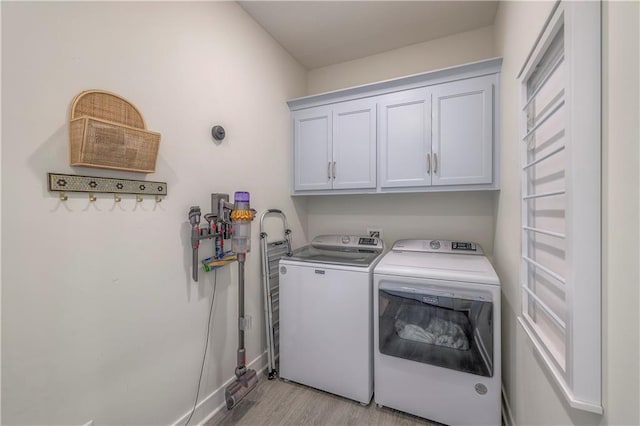 washroom with baseboards, cabinet space, independent washer and dryer, and light wood finished floors