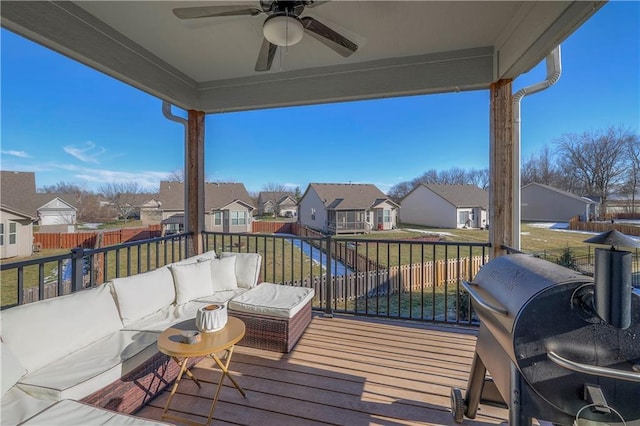 wooden deck with a grill, a residential view, ceiling fan, outdoor lounge area, and a lawn