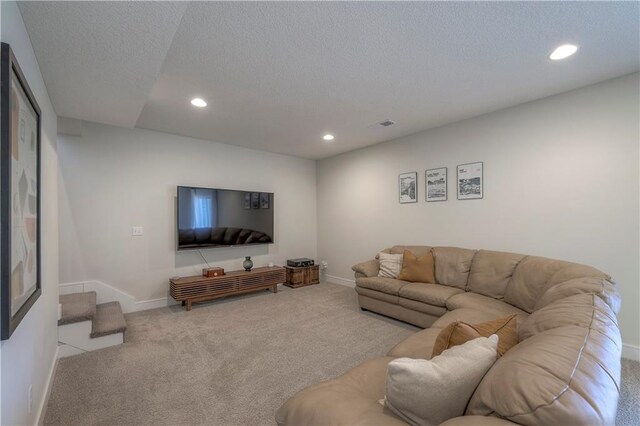 living area with carpet floors, a textured ceiling, baseboards, visible vents, and recessed lighting