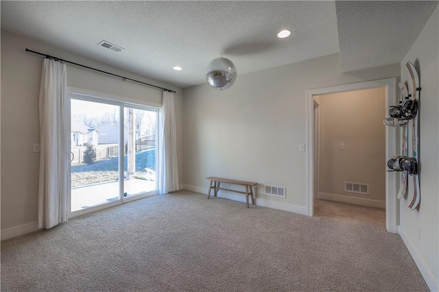 carpeted empty room featuring baseboards and visible vents