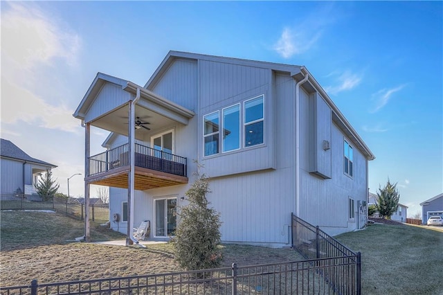 rear view of house with a fenced backyard, a balcony, and ceiling fan
