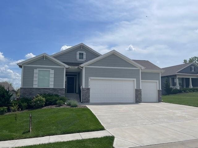 1113 SW Whitby Dr, Lees Summit, MO 64083 - craftsman house featuring concrete driveway, an attached garage, a front lawn, and stone siding