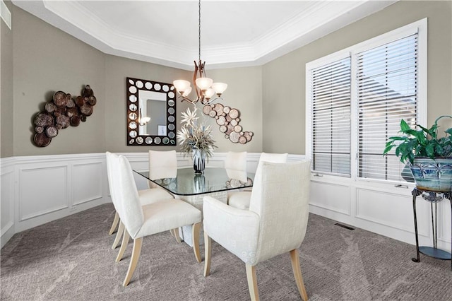 dining room featuring carpet, a notable chandelier, and a decorative wall