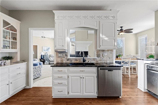 kitchen featuring stainless steel dishwasher, a sink, and white cabinetry