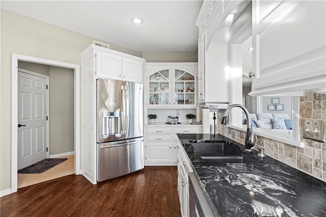 kitchen with stainless steel fridge, dark wood-style floors, glass insert cabinets, white cabinetry, and a sink