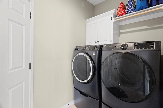 washroom featuring washer and clothes dryer and cabinet space