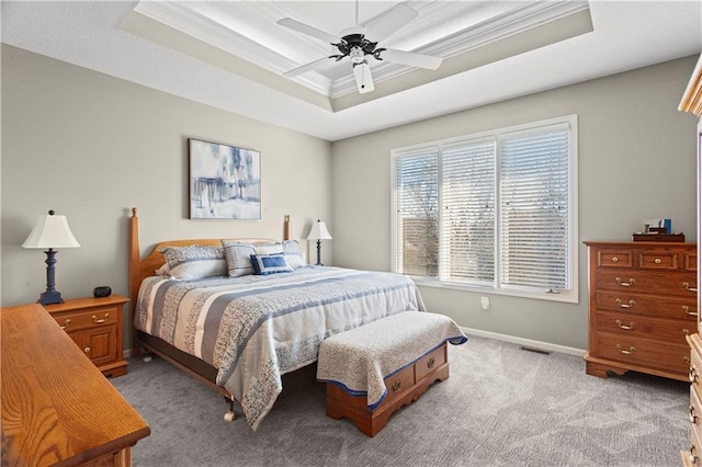 bedroom with light carpet, a ceiling fan, baseboards, ornamental molding, and a raised ceiling