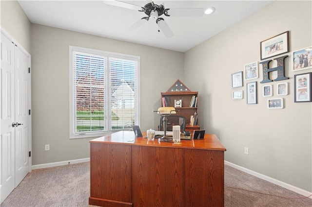 office space featuring ceiling fan, baseboards, and light colored carpet